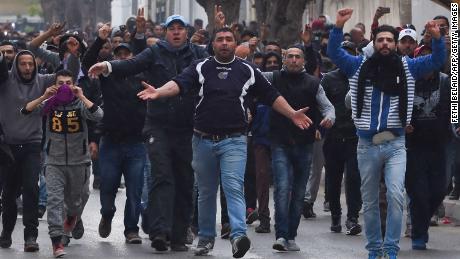Tunisian protesters gesture toward security forces during clashes in the town of Tebourba on Tuesday following the funeral of a man who died the previous day at an anti-austerity protest.