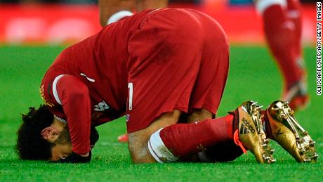 Liverpool&#39;s Egyptian midfielder Mohamed Salah puts his head on the pitch after scoring his team&#39;s fourth goal.