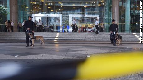 Indonesian policemen and their K9 dogs stand guard outside Jakarta&#39;s stock exchange.