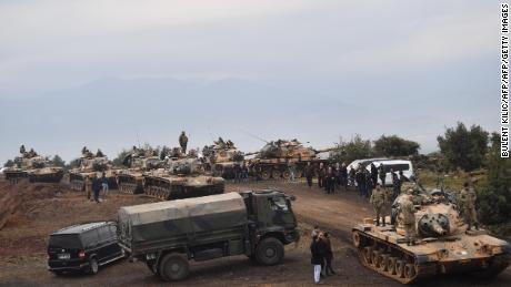 Villagers watch as Turkish army tanks and soldiers gather near the Syrian border on January 21.