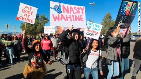 Protesters carry signs as they make their way to Sam Boyd Stadium for the Women&#39;s March rally on January 21, in Las Vegas, Nevada.
