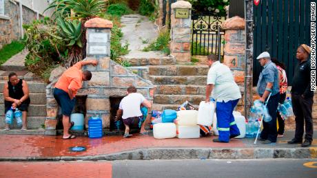 People collect drinking water from pipes fed by an underground spring in St. James, about 25 kilometers from the city center of Cape Town. 