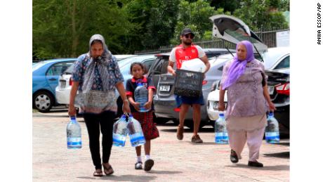 People carry water collected from a natural spring earlier this week in Cape Town.