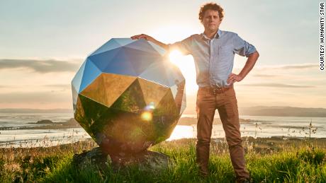 Peter Beck, creater of The Humanity Star, poses next to the satellite.