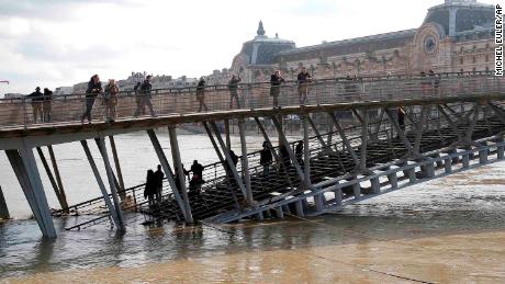 People examine the Seine river from the Leopold-Sedar-Senghor bridge in Paris on Friday. 