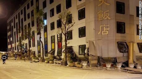 Rescue workers gain entry after the building collapsed onto its side following an early morning earthquake in Hualien.