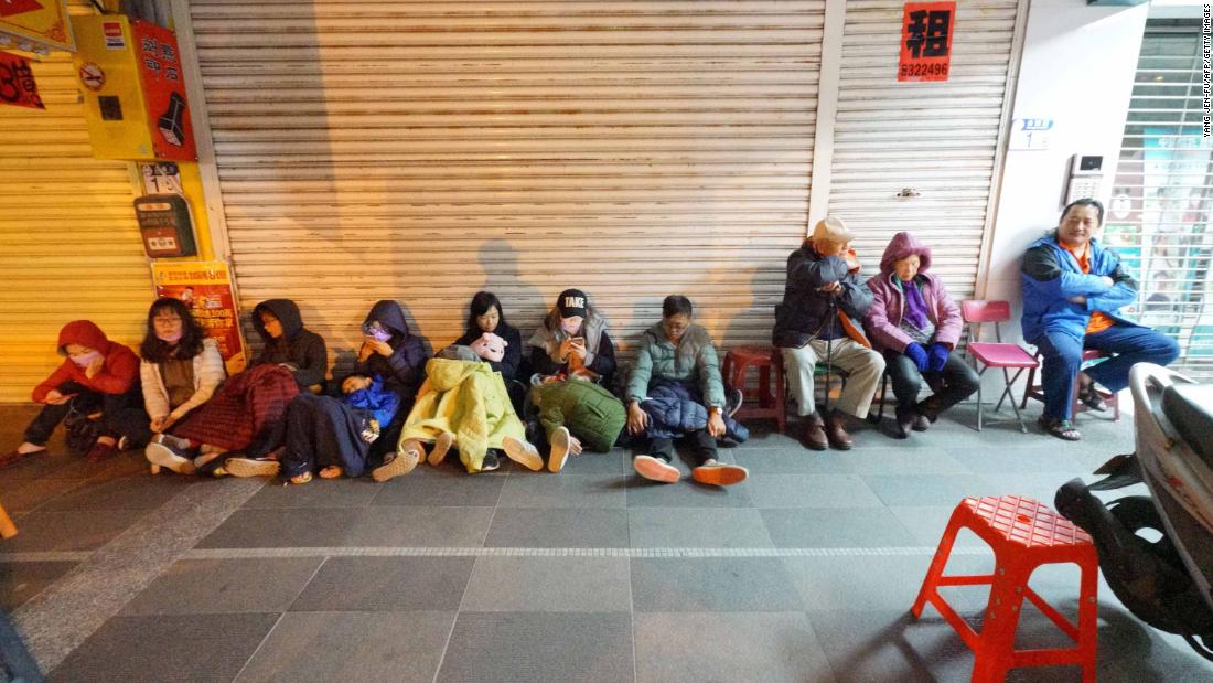 Guests of the quake-damaged Marshal Hotel take refuge outside on February 7.