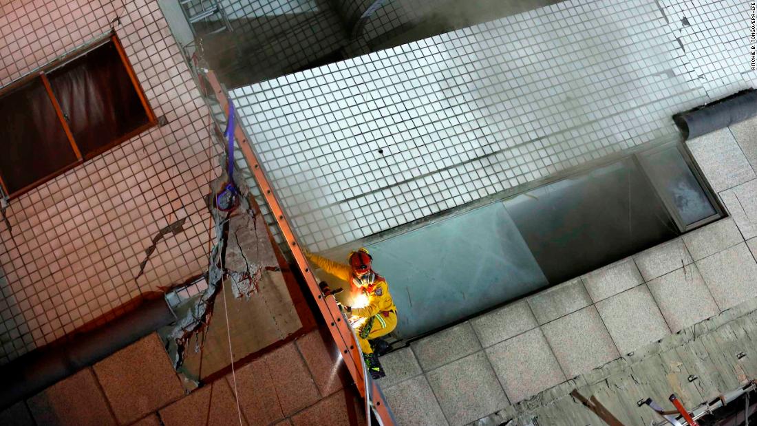 A rescuer scales a damaged building in search of survivors.