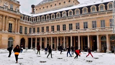 Children play in the snow in the Palais Royal garden on Wednesday.