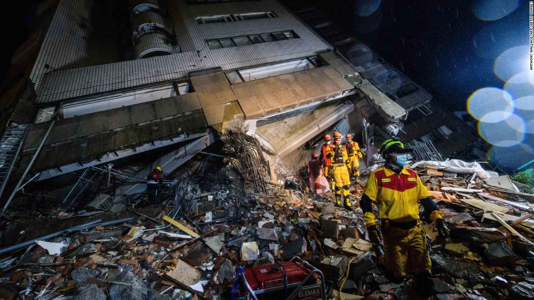 Rescue workers climb over debris at the Yun Tsui building.