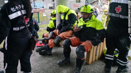 Rescuers rest near the site of damaged buildings in Hualien on February 8.