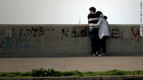 A Lebanese couple embrace as they stand on the seaside in Dbayeh north of Beirut, on February 7, 2014. AFP PHOTO/JOSEPH EID        (Photo credit should read JOSEPH EID/AFP/Getty Images)