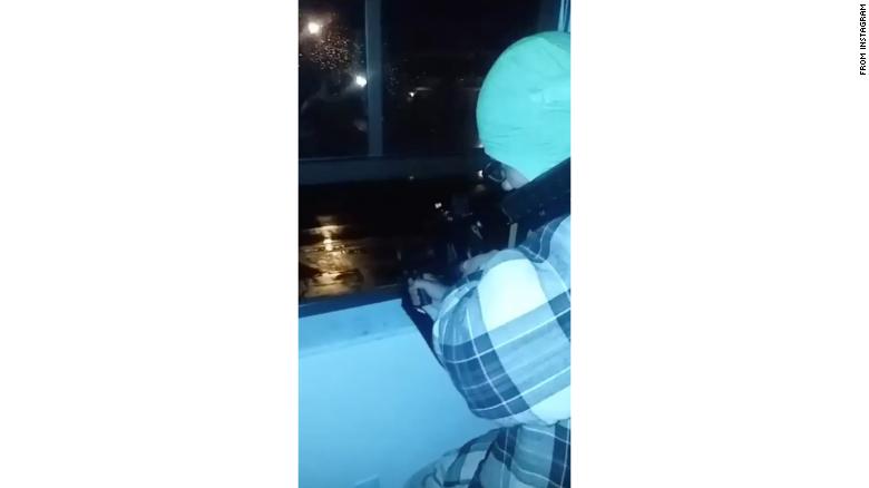 A screenshot from a video showing Nikolas Cruz firing a gun out of a window.
