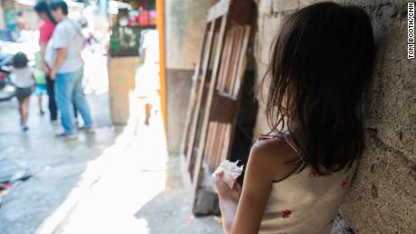 A young girl looks on a bustling street in Manila&#39;s Tondo neighborhood.