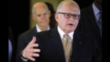 The president of Florida International University, Mark Rosenberg, speaks to reporters with Florida Gov. Rick Scott behind him. Rosenberg said FIU followed required processes during the bridge's construction and all contractors were certified by the state.