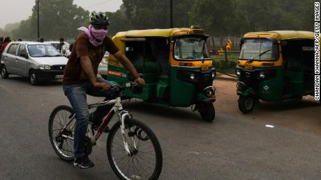 A man covers his face as he cycles during a dust storm in New Delhi, May 2.