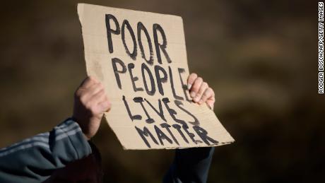 A man holds a sign during a protest calling for affordable housing close to the city centre for disadvantaged people, organised by the group Reclaim the City, over the N2 highway in Woodstock, Cape Town, on July 11, 2017.
Reclaim the City says the government should be doing more to provide affordable accommodation closer to the city centre. South Africa&#39;s slowing economy and political uncertainty have curtailed the property market countrywide. But Cape Town has proved to be an exception, with houses here on average 78.5 percent more expensive than they were in 2010, according to the South African FNB bank.
 / AFP PHOTO / RODGER BOSCH        (Photo credit should read RODGER BOSCH/AFP/Getty Images)