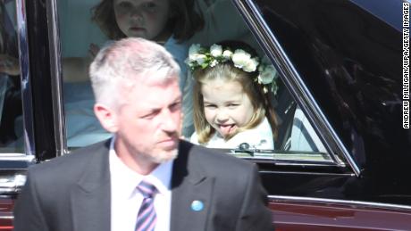 Princess Charlotte, sticking out her tongue, arrives at the wedding ceremony.
