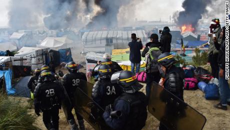French anti-riot police officers arrive in October 2016 to clear the Calais &quot;Jungle&quot;. 