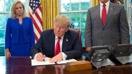 President Donald Trump signs an executive order to keep families together at the border, but says that the &#39;zero-tolerance&#39; prosecution policy will continue, during an event in the Oval Office of the White House in Washington, Wednesday, June 20, 2018. Standing behind Trump are Homeland Security Secretary Kirstjen Nielsen, left, and Vice President Mike Pence. (AP Photo/Pablo Martinez Monsivais)