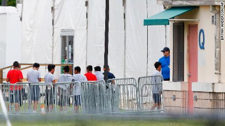 Immigrant children walk in a line outside the Homestead Temporary Shelter for Unaccompanied Children, a former Job Corps site that now houses them, on Wednesday, June 20, 2018, in Homestead, Fla. (AP Photo/Brynn Anderson)