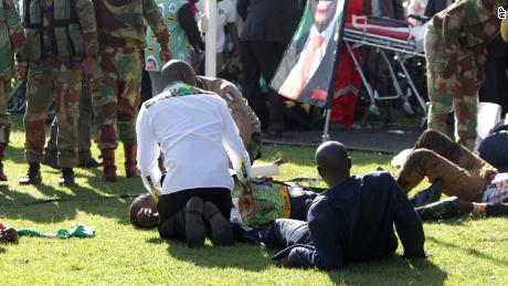 Injured people receive help after Saturday&#39;s blast in Bulawayo. CNN has blurred the faces of the injured.