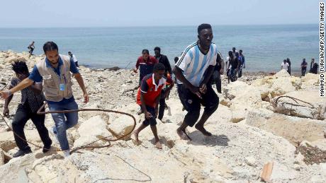   Migrants who survived the sinking escalate the rocky coastline of the city. al-Hmidiya, east of the capital Tripoli 