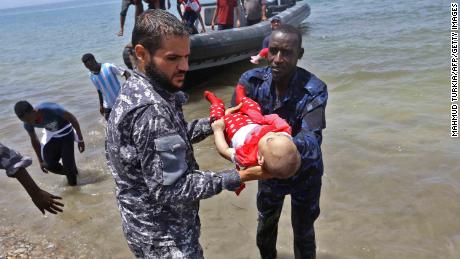   The survivors arrive ashore then that two men hold the body of one of the three babies 