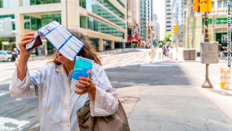   A woman tries to protect herself from the sun in Philadelphia, Pennsylvania. 