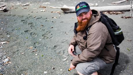 Drew Hamilton, from Friends of McNeil River, finds bear tracks on Amakdedori Beach.