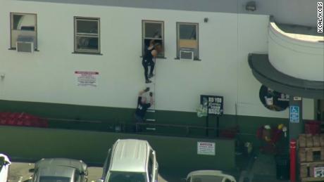 People crawl out of windows at a Trader Joe&#39;s in Los Angeles.