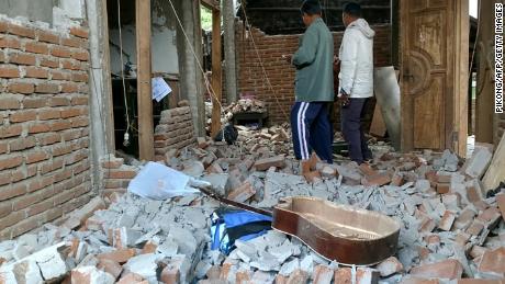 Villagers walk through a house that was damaged after a 6.4 magnitude earthquake struck in Lombok on July 29.