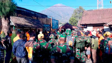Indonesian soldiers and rescue teams gather to prepare for evacuating tourists from Mount Rinjani, seen in the background, at Sembalun in East Lombok on Monday.