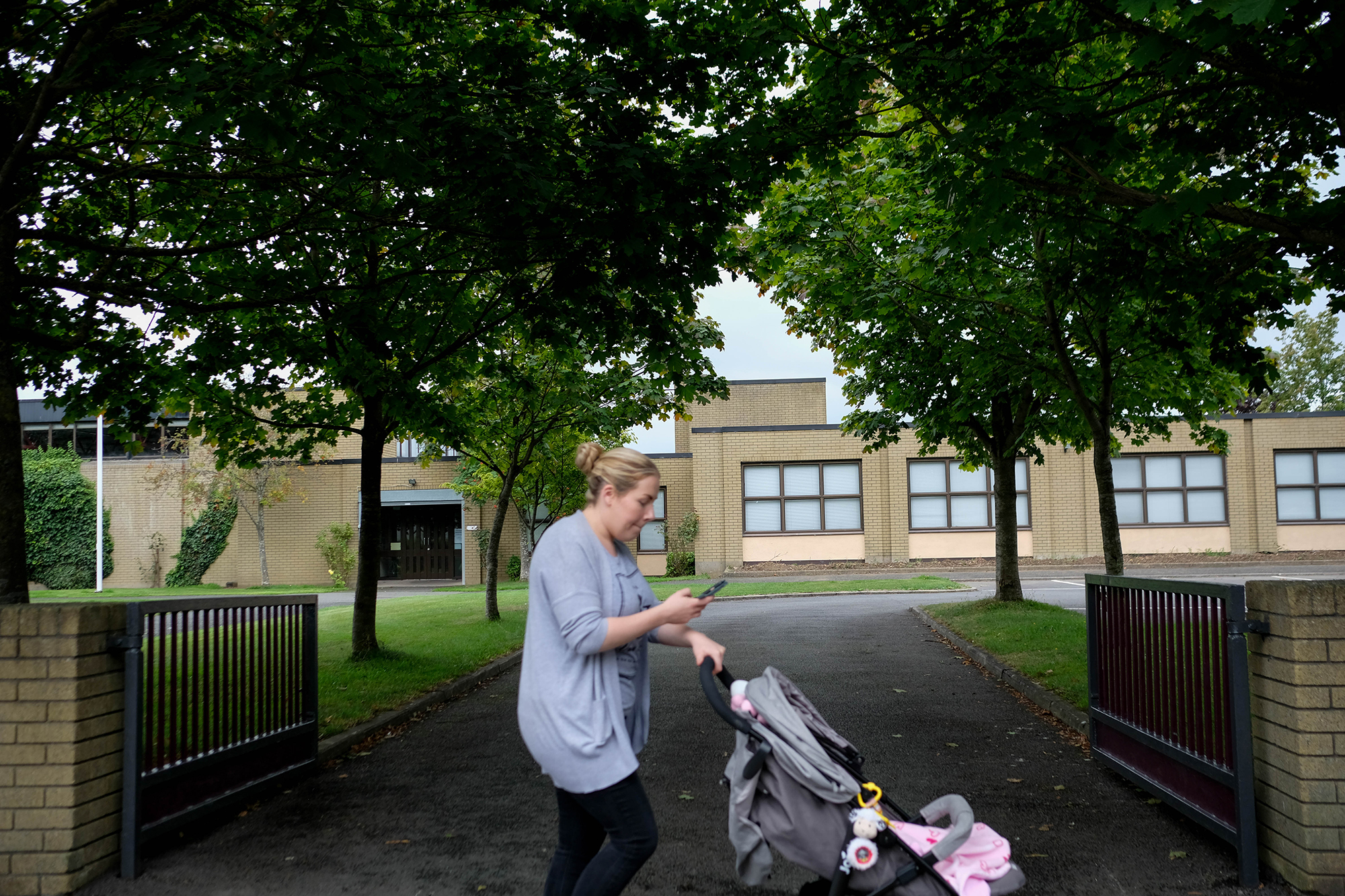 A woman passes one of the three Catholic primary schools on the green avenue of Leixlip.
