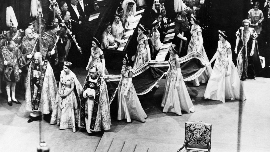Elizabeth ascended to the throne in February 1952, 마가렛 공주는 약 여름 드레스를 입는다. 56. 여기, 그녀는 6월 대관식에서 제단으로 걸어갑니다. 2, 1953.