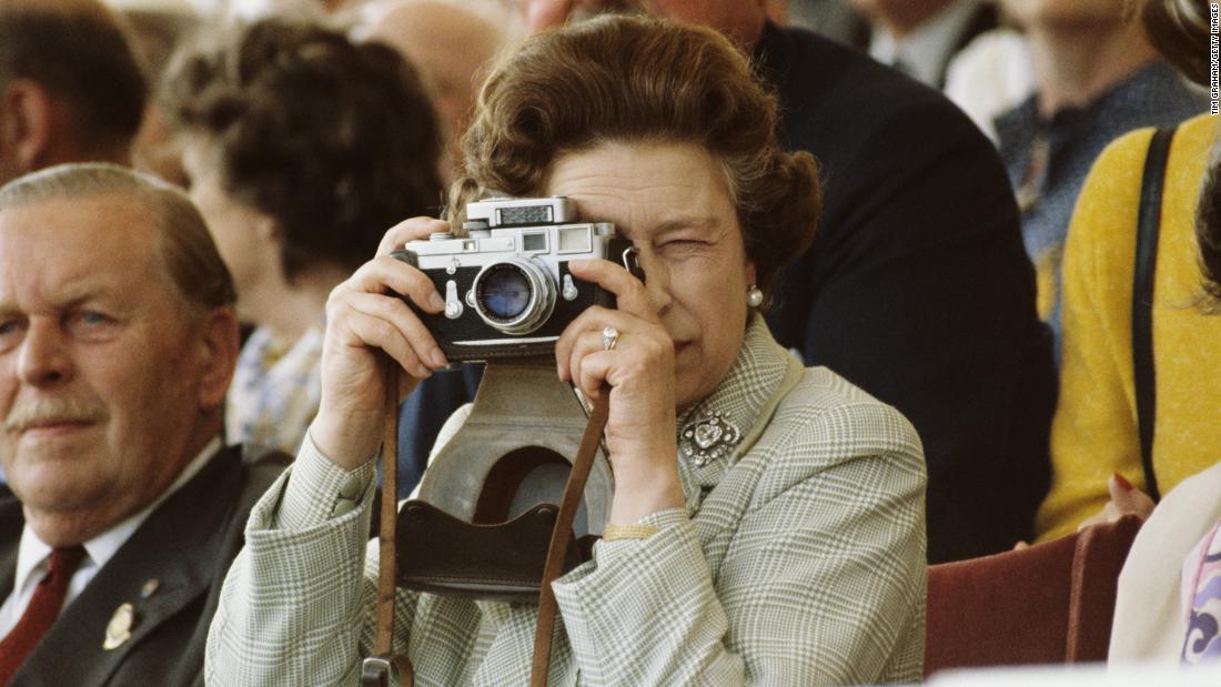 Elizabeth takes pictures of her husband during a horse show in Windsor in May 1982.