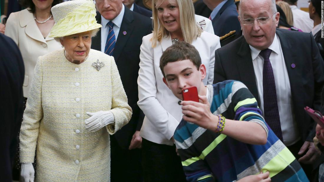 A boy in Belfast, Noord-Ierland, takes a selfie in front of the Queen in June 2014.