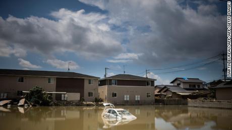 A car is in the water after the area was devastated by floods and landslides in Mabi, Okayama Prefecture, on July 10, 2018. 