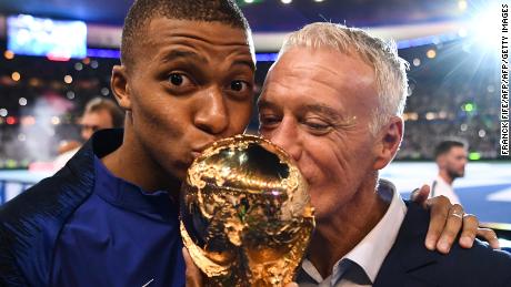 Mbappe and France coach Didier Deschamps kiss the World Cup as they celebrate during a ceremony in Paris after victory over the Netherlands.