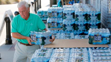 Larry Pierson, from the Isle of Palms, S.C., purchases bottled water from the Harris Teeter grocery store on the Isle of Palms in preparation for Hurricane Florence at the Isle of Palms S.C., Monday, Sept. 10, 2018. (AP Photo/Mic Smith)
