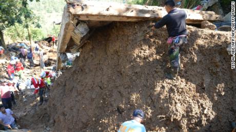 Rescuers dig at a landslide site where dozens of residents are believed to have been buried.