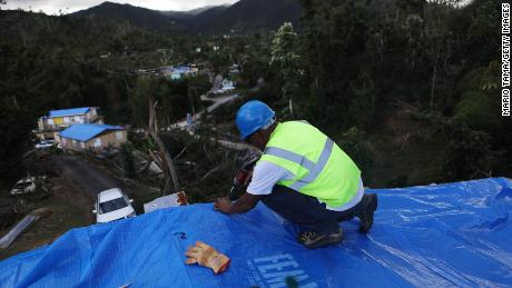 A contractor helps apply a FEMA tarp to a Morovis home on December 20th. 