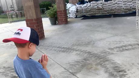 Brad Whiteis took a picture of his son Carter, 5, praying outside his school in Conway, South Carolina, while the area is still threatened by floods.