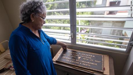 Diana Aponte watches a memorial to her husband, who died two months after the storm.