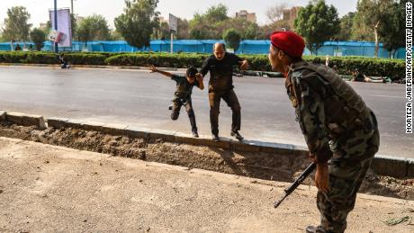 A man and a boy run to escape the artillery fire in Ahvaz.