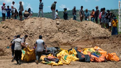 Officials carry body bags to a mass grave in preparation for the funeral of the victims of the Palu earthquake on Monday.