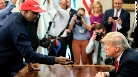 Rapper Kanye West, left, shows a picture of a plane on the phone with US President Donald Trump at a meeting in the White House Oval Office on October 11, 2018 in Washington, DC. 