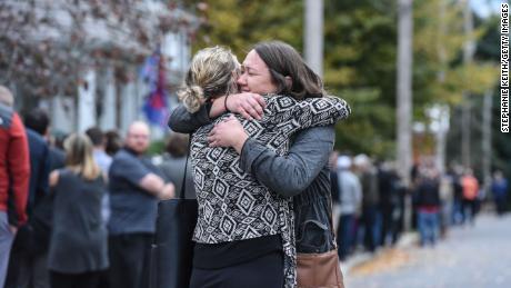 Two people in mourning kiss after leaving a service at the Roman Catholic St. Stanislaus Church.