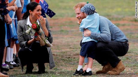 Britain&#39;s Prince Harry and Meghan, Duchess of Sussex are embraced by Luke Vincent, 5, on their arrival in Dubbo, Australia.