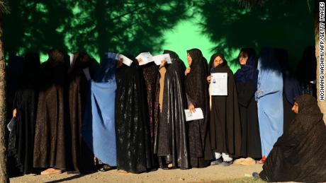 Afghan women wait in line to vote Saturday at a polling center in Herat province.